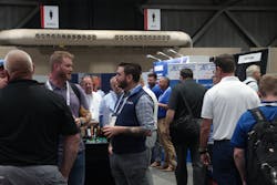 Attendees and vendors continue conversations during the Networking Happy Hour on the exhibit floor.