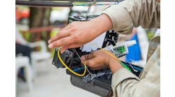 Technician installing cabinet on fiber optic cable. Technician installing cabinet on fiber optic cable.
