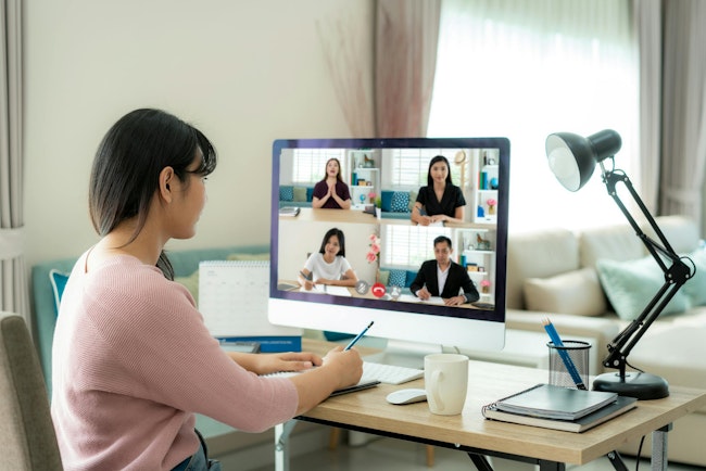 Back View Of Business Woman Talking To Her Colleagues About Plan In Video Conference