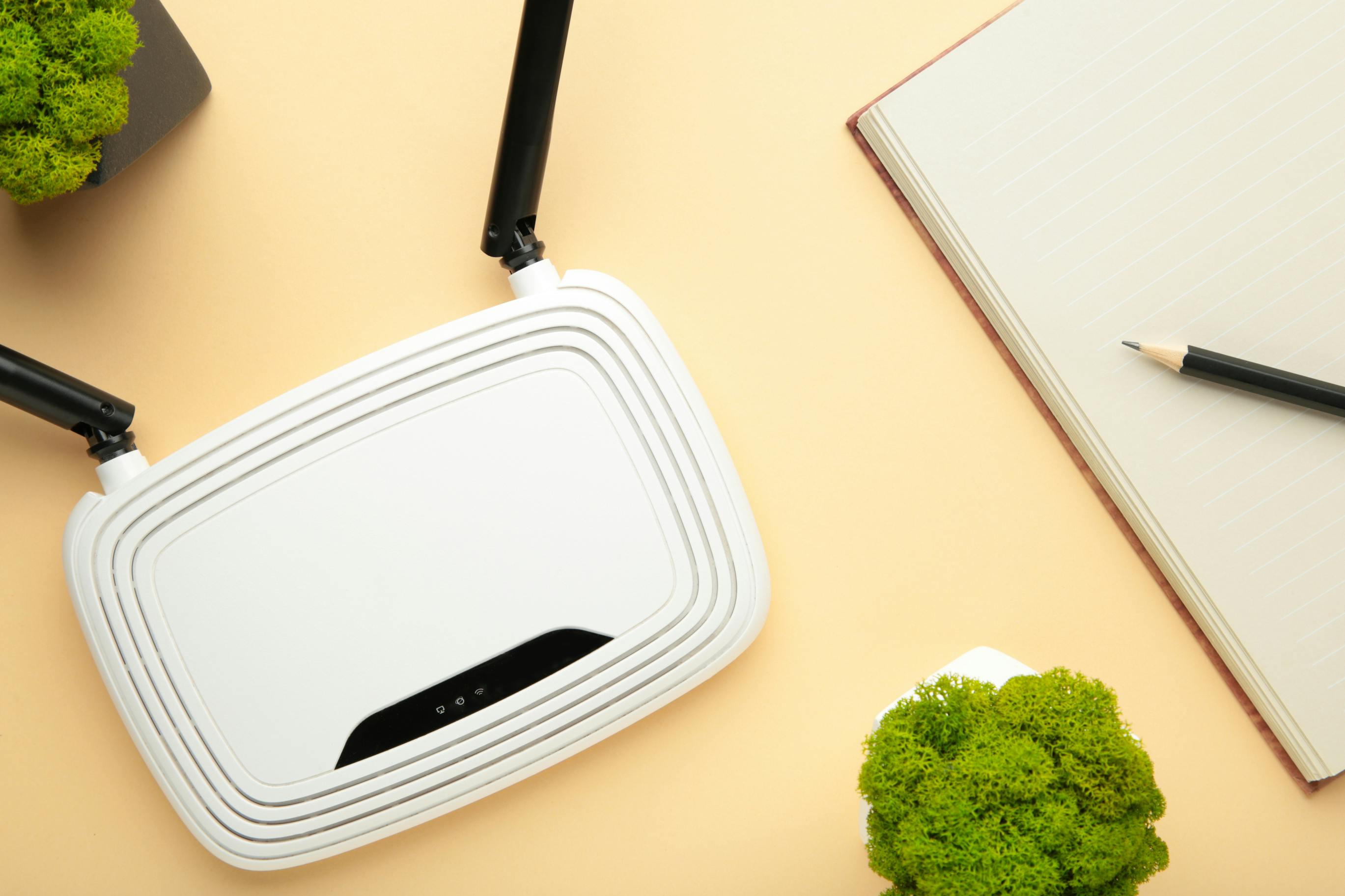 Wireless Wi Fi Router On Beige Background With Notebook On Beige