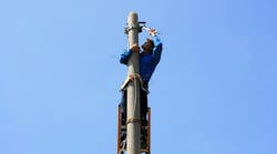 Electrician on the tower electric pole. Electrician stays on the tower electric pole and repairs a wire of the power line Electrician on the tower electric pole. Electrician stays on the tower electric pole and repairs a wire of the power line