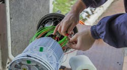 Fiber Optic Technician Rolls Of Fiber Optic Cables Inside A Splice Organizer Tray Fiber Optic Technician Rolls Of Fiber Optic Cables Inside A Splice Organizer Tray