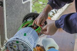 Fiber Optic Technician Rolls Of Fiber Optic Cables Inside A Splice Organizer Tray Fiber Optic Technician Rolls Of Fiber Optic Cables Inside A Splice Organizer Tray