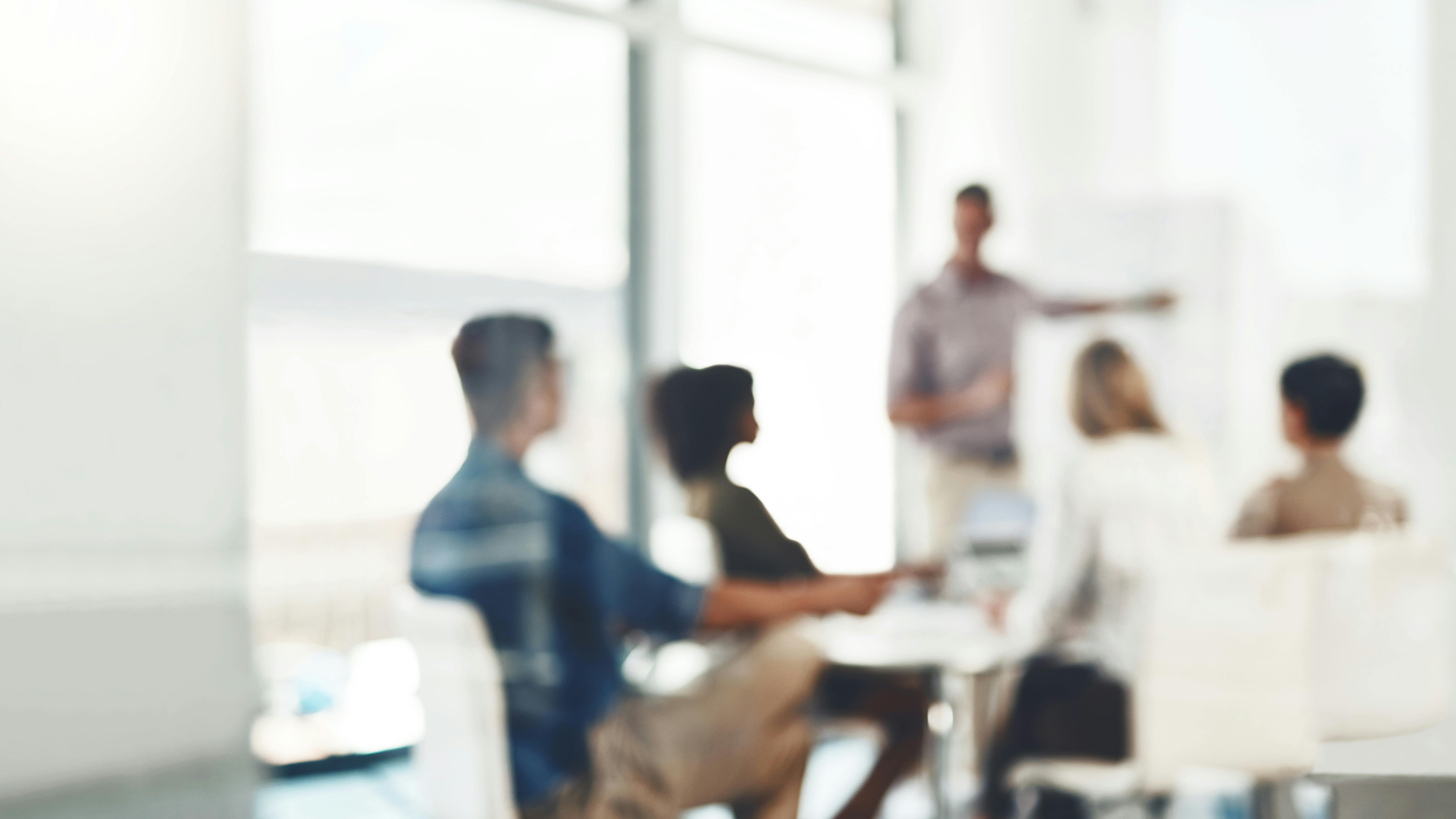 Sem-obscured image of team memebers in a meeting.