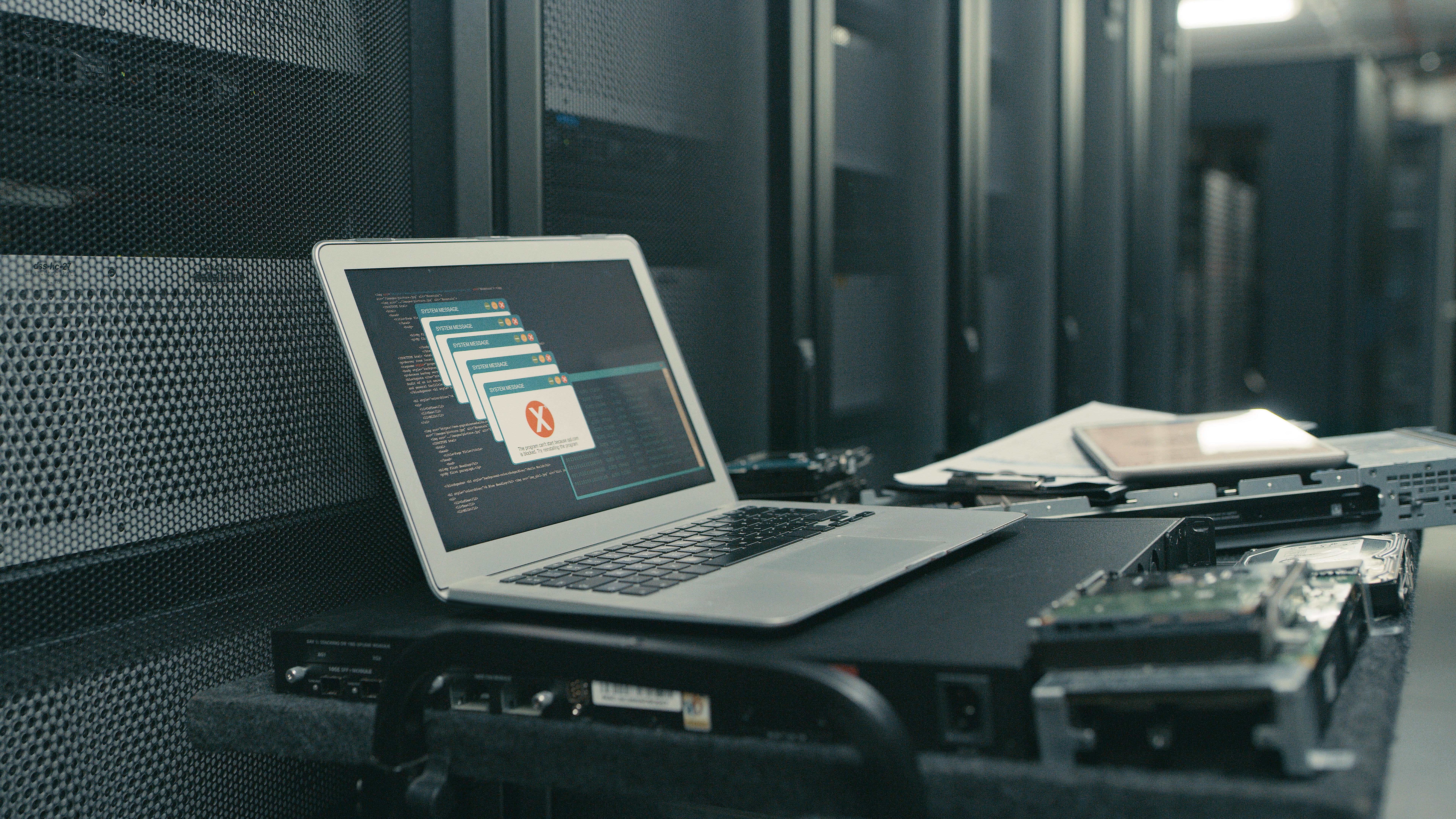 A laptop with an error message on the screen in an empty server room.