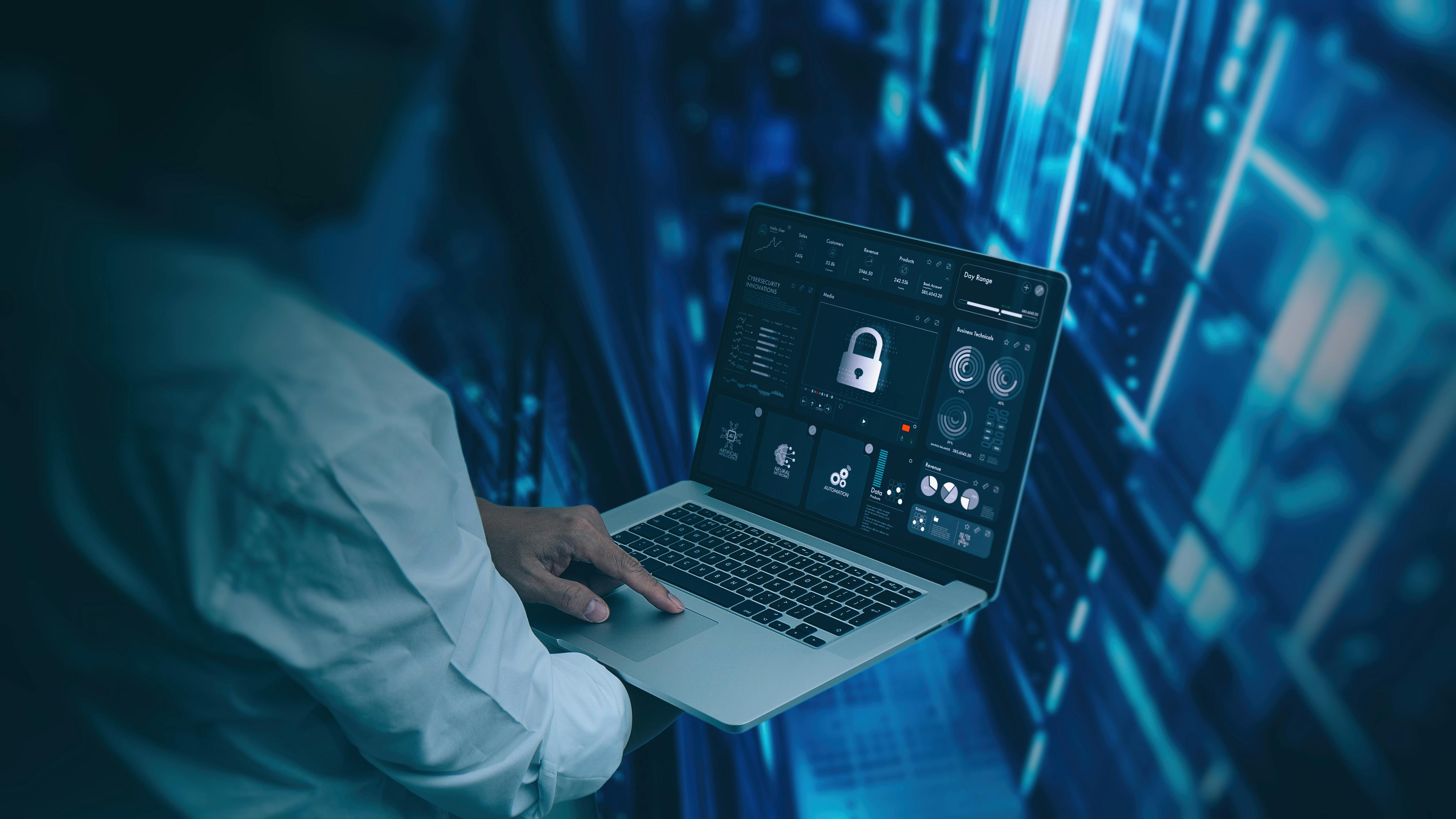 Engineer working on laptop computer showing a pad lock icon in a modern server room