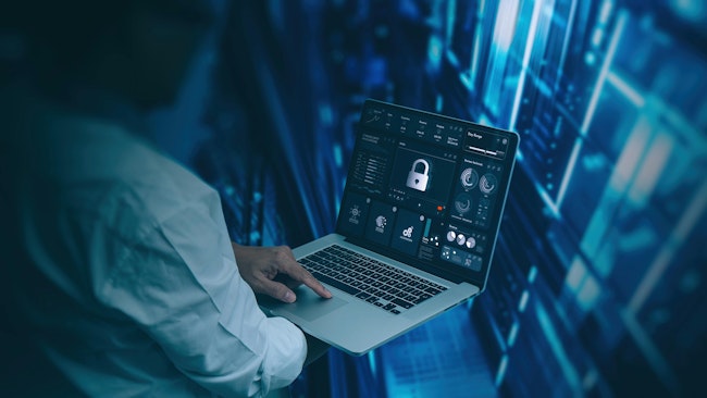 Engineer working on laptop computer showing a pad lock icon in a modern server room