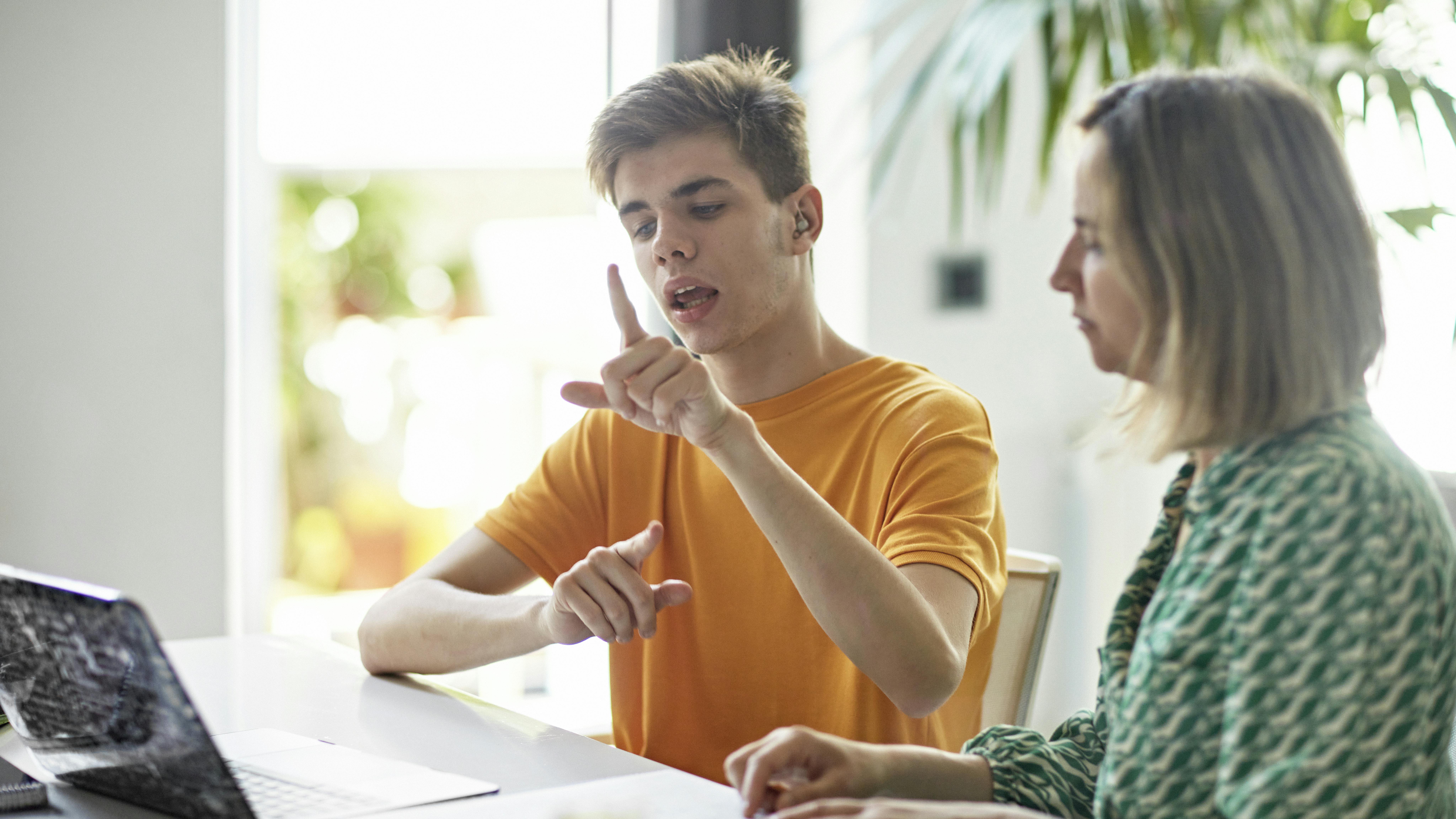 Young man using sign language on a computer